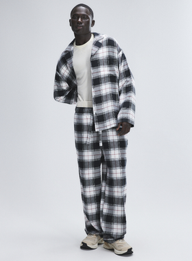 A man wearing Savage x Fenty dove white plaid
