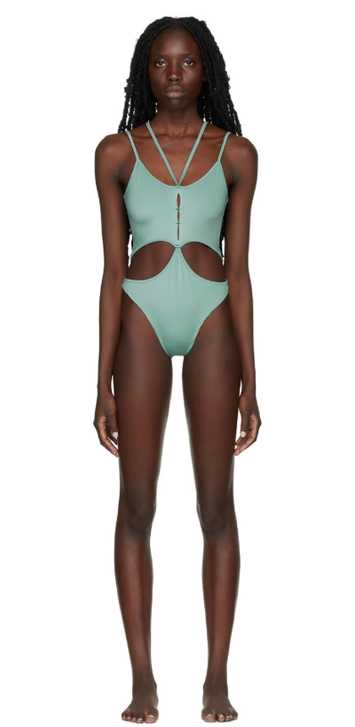 A woman wearing Rui ssense exclusive green one-piece swimsuit