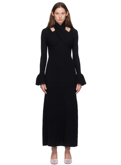 A woman wearing Rokh black cross knitted maxi dress