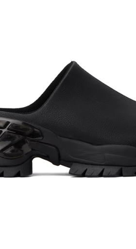 A woman wearing Rombaut black illusion mules