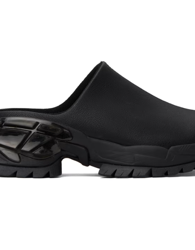 A woman wearing Rombaut black illusion mules