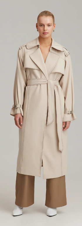 A woman wearing C/MEO Collective definition trench