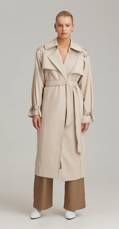 A woman wearing C/MEO Collective definition trench