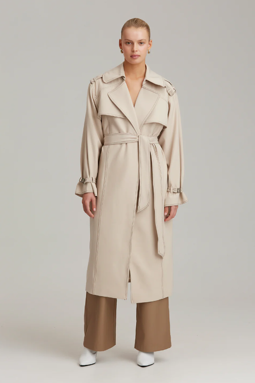 A woman wearing C/MEO Collective definition trench