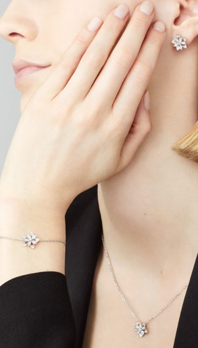 A woman wearing Van Cleef lotus openwork earrings mini model