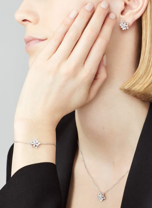 A woman wearing Van Cleef​ lotus openwork earrings mini model