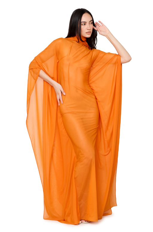A woman wearing LaQuan Smith mockneck gown with sweeping dolman sleeves