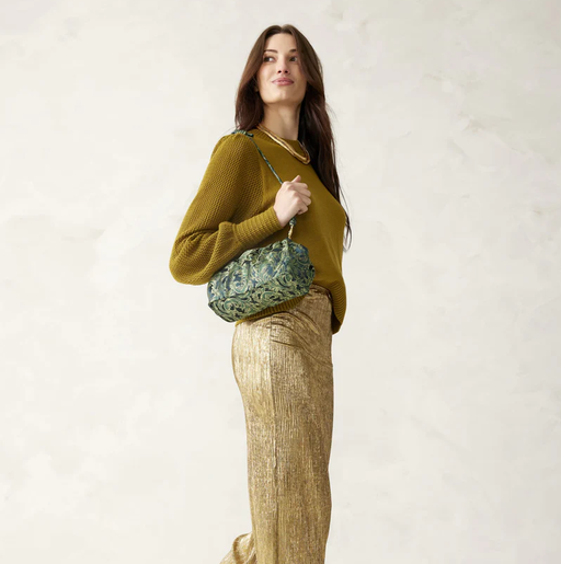A woman carrying Vera Bradley wicked taber dumpling bag