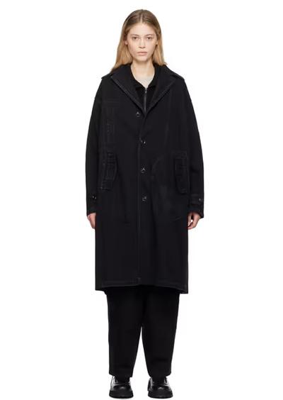 A woman wearing Y's black faded denim coat