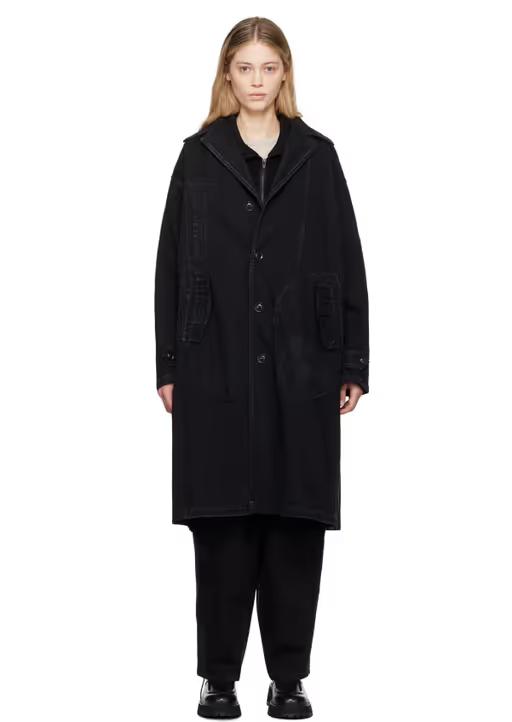 A woman wearing Y's black faded denim coat
