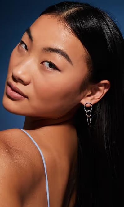 A woman wearing Accessorize sterling silver-plated circle drop earrings