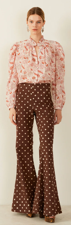 A woman wearing a Alix of Bohemian pink blouse and brown polka dot pants
