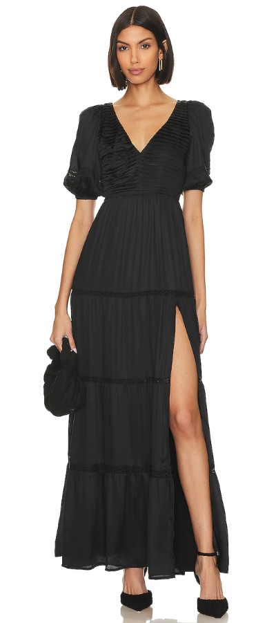 A woman wearing a black TULAROSA dress and heels
