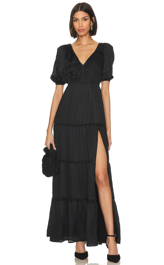 A woman wearing a black TULAROSA dress and heels