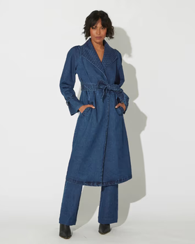 A woman wearing a blue Cleobella suit dress and heels