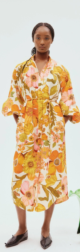 A woman wearing a yellow floral Alemais dress