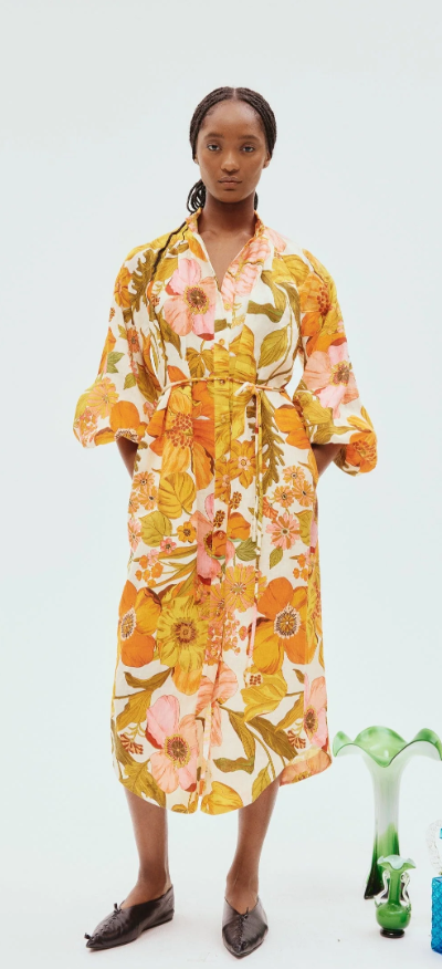 A woman wearing a yellow floral Alemais dress