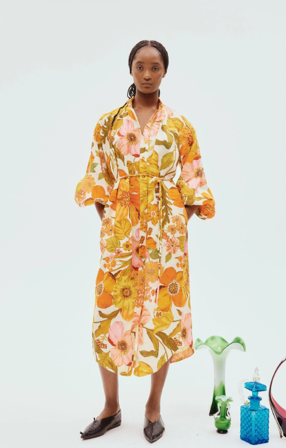 A woman wearing a yellow floral Alemais dress