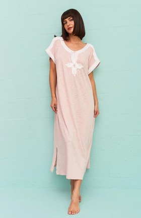 A wiman wearing a light pink Pitusa dress