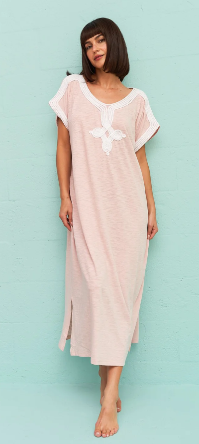 A wiman wearing a light pink Pitusa dress