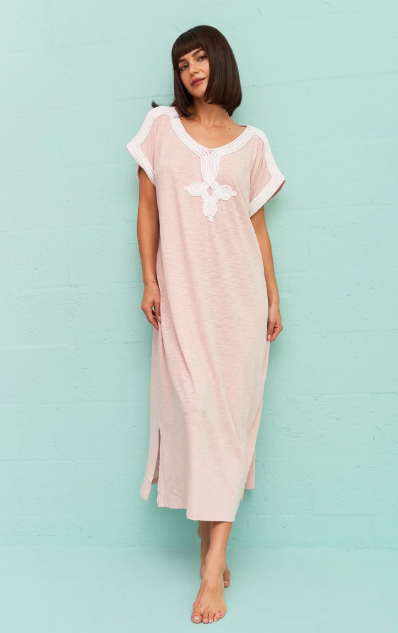 A wiman wearing a light pink Pitusa dress