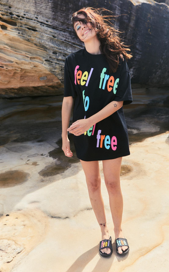A man wearing a black Romance Was Born 'free' t-shirt and matching slides