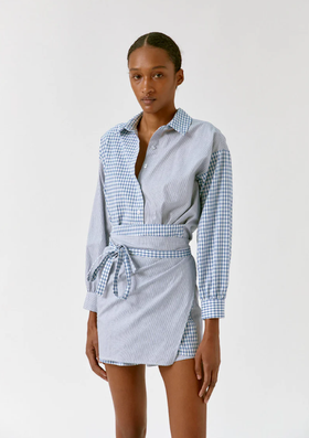 A woman wearing a Musier Paris trench coat in brown with blue jeans underneath