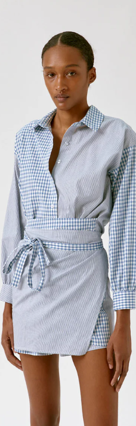 A woman wearing a Musier Paris trench coat in brown with blue jeans underneath