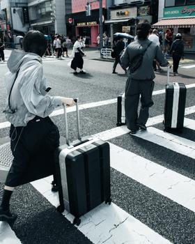 A man carrying a beige Db roller bag
