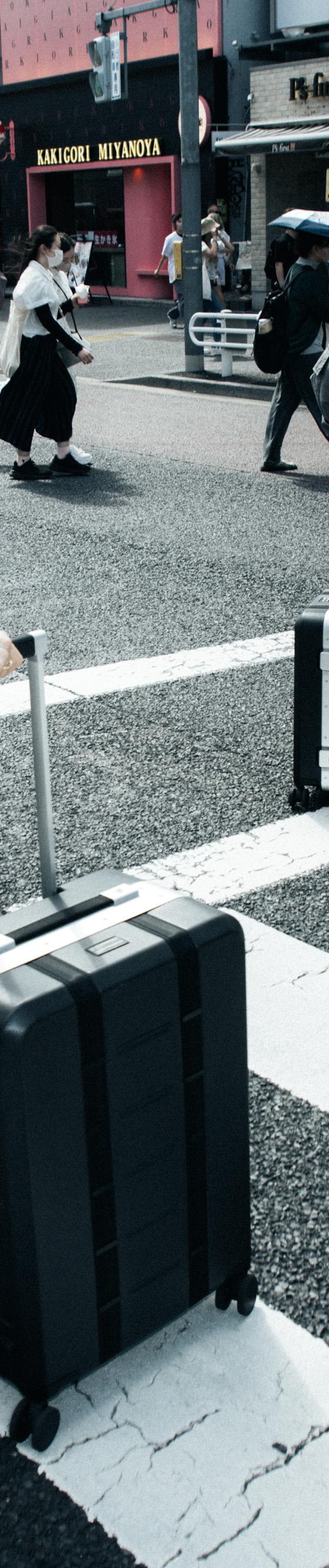 A man carrying a beige Db roller bag