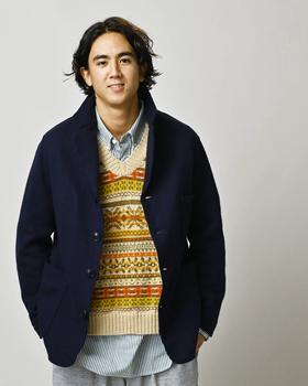 A man wearing a navy 45R jersey-melton jacket over a Fair Isle knit vest