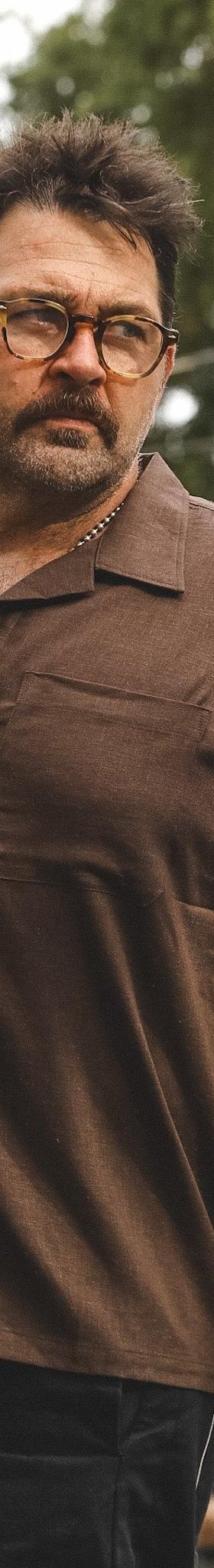 A man wearing a brown A New Medium camp collar shirt