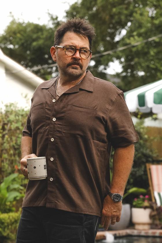A man wearing a brown A New Medium camp collar shirt