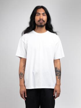 A man wearing a white ADAPTURE t-shirt with black trousers