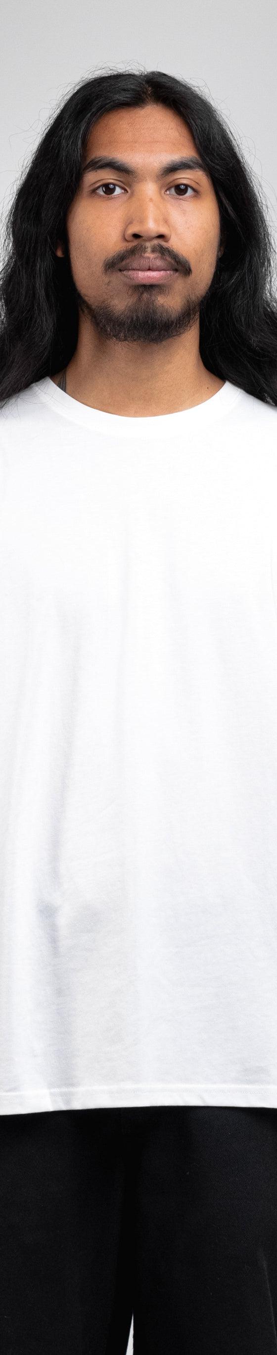 A man wearing a white ADAPTURE t-shirt with black trousers