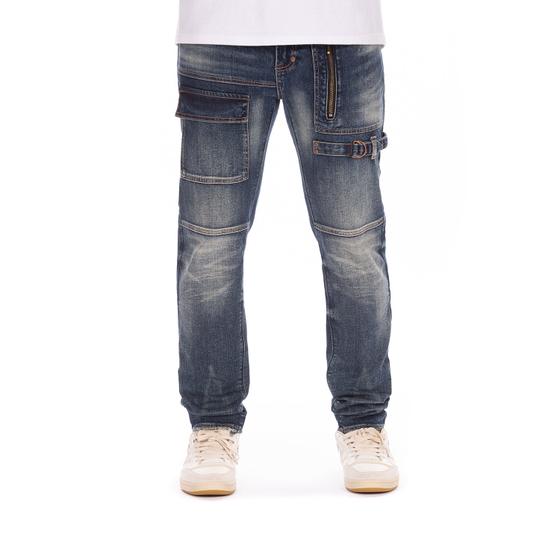 A man wearing dark-wash AKOO utility denim jeans with zip and cargo pockets