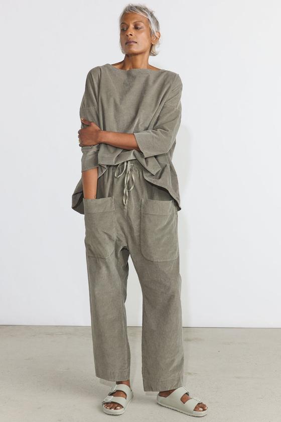 A woman wearing a taupe Album di Famiglia boat-neck top and wide drawstring trousers