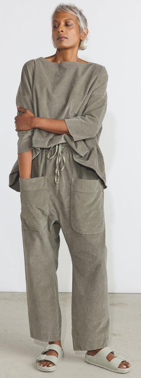 A woman wearing a taupe Album di Famiglia boat-neck top and wide drawstring trousers