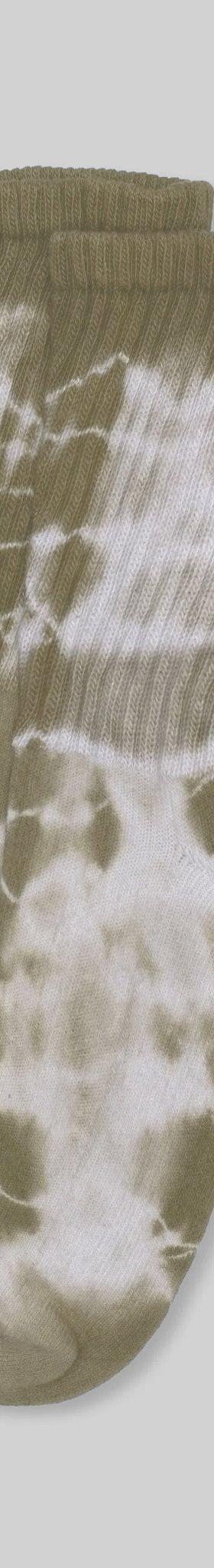 A pair of olive and cream tie-dye American Trench mill-knit crew socks on a plain grey background
