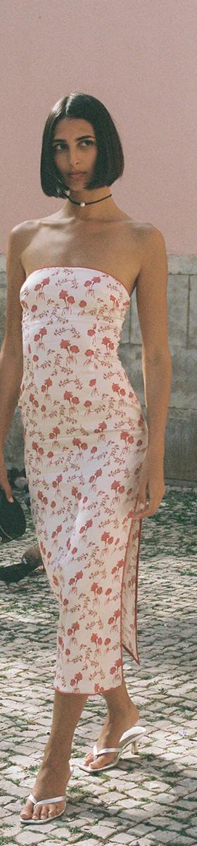 A woman wearing a floral-print strapless Amlul midi dress on a cobbled street
