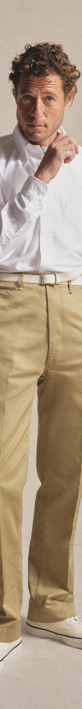 A man wearing a white long-sleeve shirt and khaki Anatomica chinos