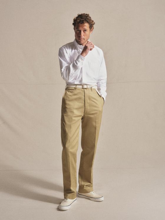 A man wearing a white long-sleeve shirt and khaki Anatomica chinos