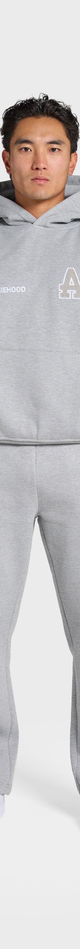 A man wearing a grey ANNIE HOOD monogrammed hoodie and matching sweatpants