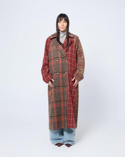 A woman wearing a red and brown patchwork checked Arthur Apparel coat with wide-leg jeans