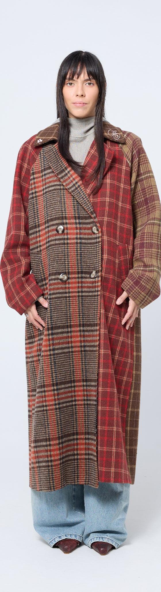 A woman wearing a red and brown patchwork checked Arthur Apparel coat with wide-leg jeans