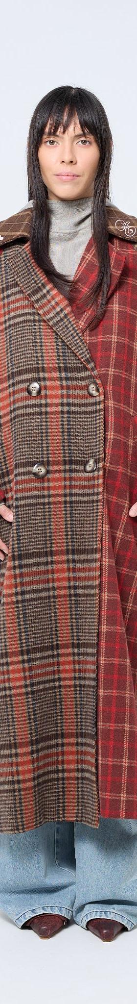 A woman wearing a red and brown patchwork checked Arthur Apparel coat with wide-leg jeans