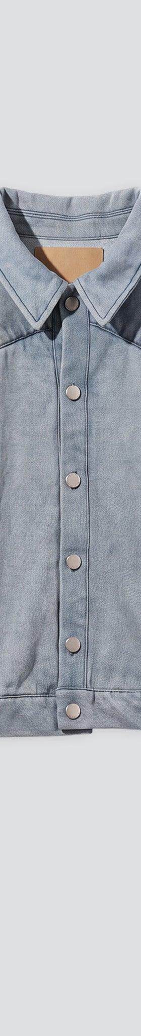 A pale blue washed denim trucker jacket on a plain grey background