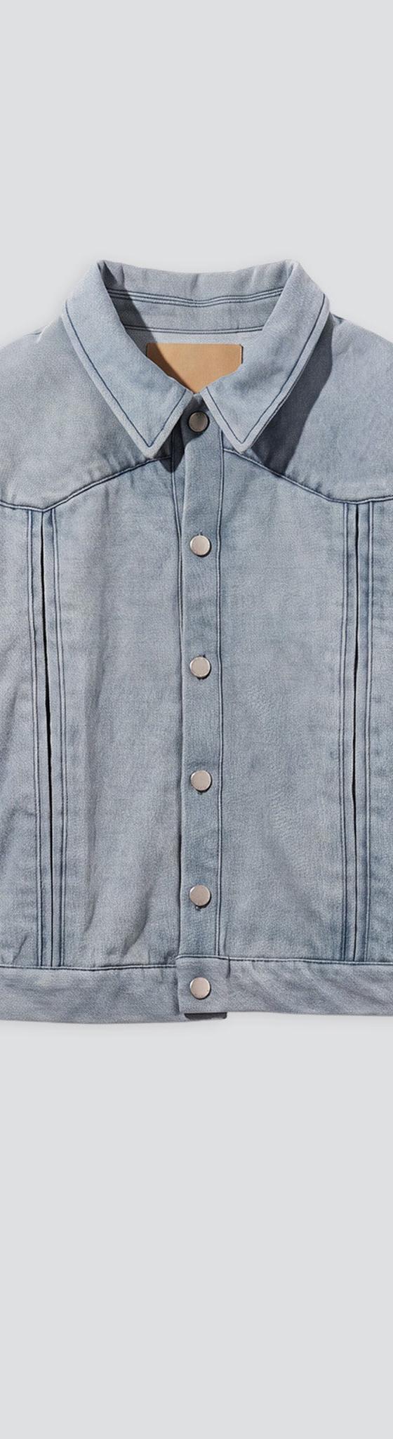 A pale blue washed denim trucker jacket on a plain grey background