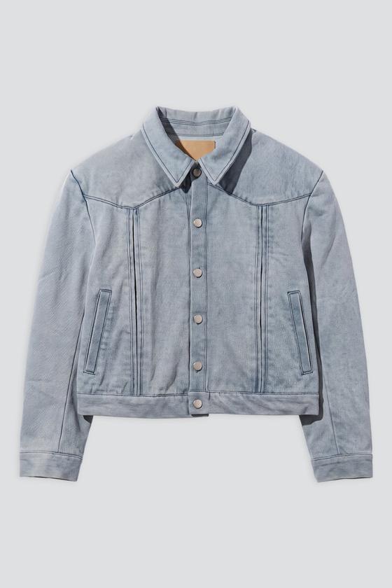 A pale blue washed denim trucker jacket on a plain grey background