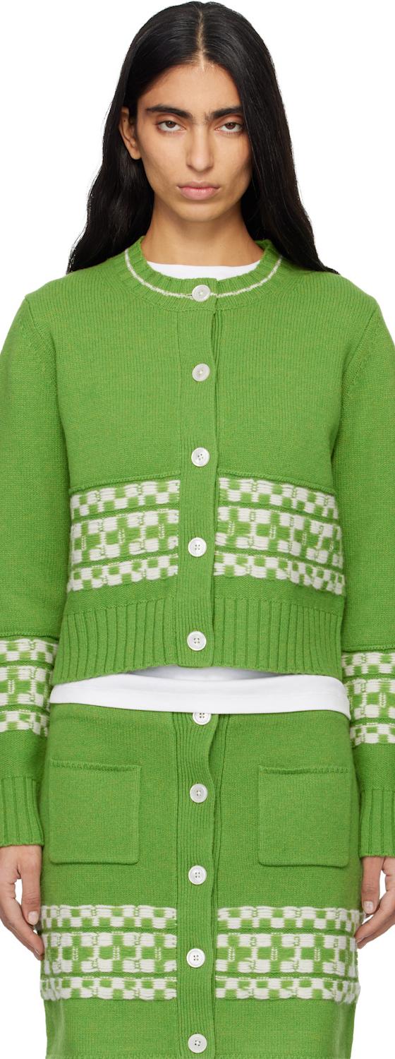 A woman wearing a green checkerboard-trimmed B.B. Wallace knit cardigan and matching skirt